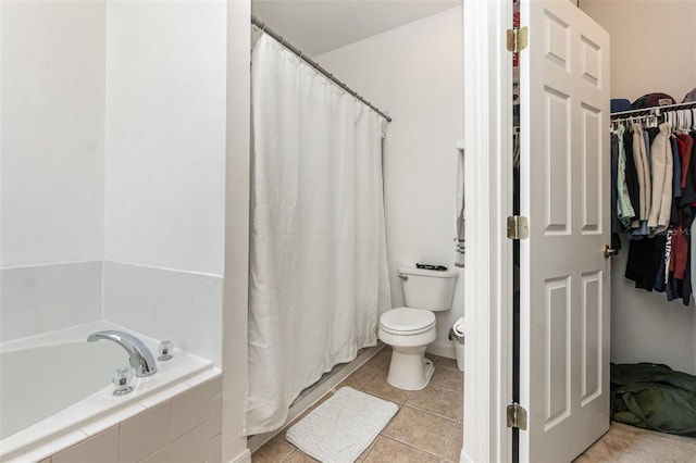 bathroom with tiled tub, tile patterned floors, and toilet