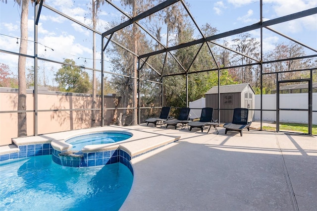 view of swimming pool with an in ground hot tub, a storage shed, a lanai, and a patio