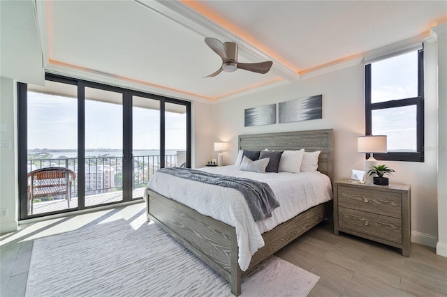 bedroom featuring a wall of windows, access to outside, ornamental molding, ceiling fan, and light hardwood / wood-style floors