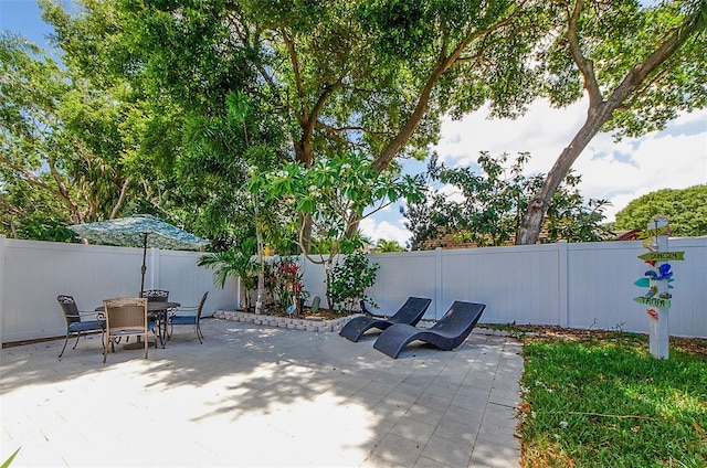 view of patio with a fenced backyard and outdoor dining area