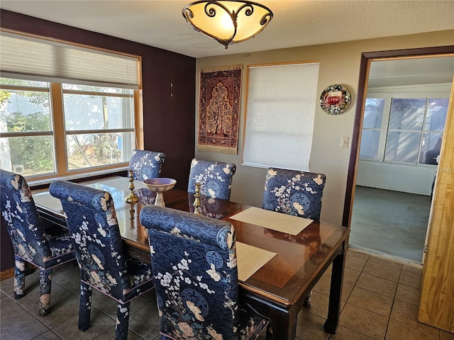 tiled dining area with a textured ceiling