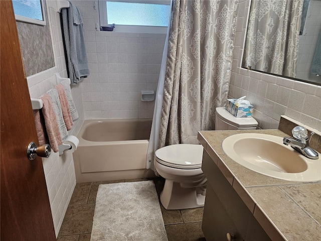 full bathroom featuring vanity, toilet, shower / tub combo, and tile walls