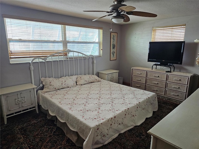 bedroom with ceiling fan and a textured ceiling