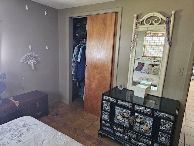 bedroom with dark tile patterned floors and a closet