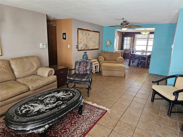 living room with light tile patterned floors, a textured ceiling, and ceiling fan