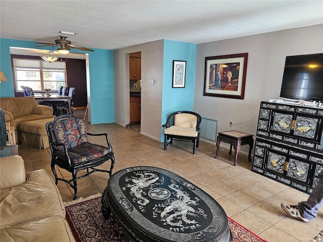 tiled living room with ceiling fan and a textured ceiling