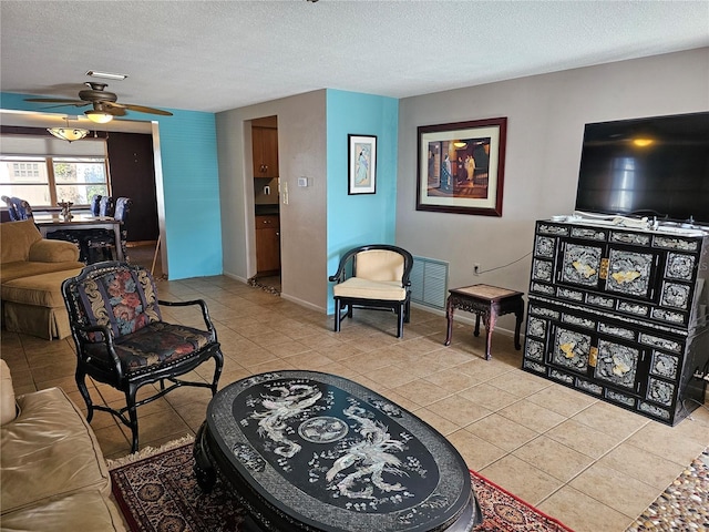 tiled living room featuring ceiling fan and a textured ceiling