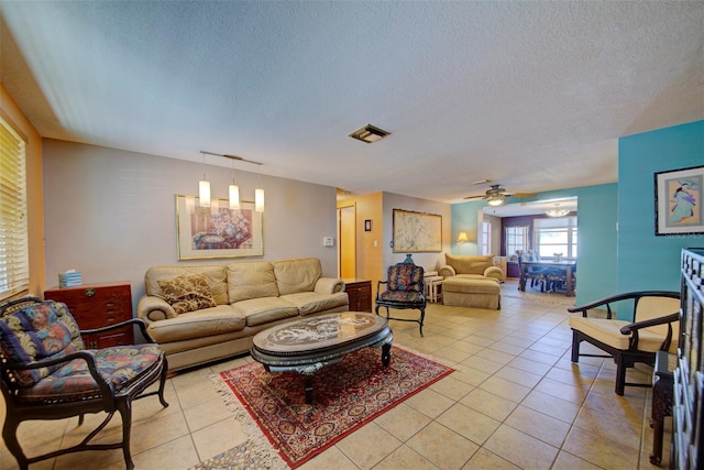 living room with a textured ceiling and light tile patterned flooring