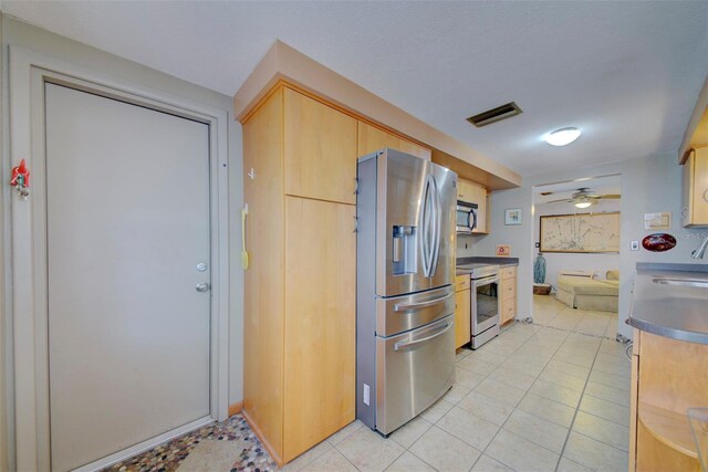 kitchen featuring ceiling fan, appliances with stainless steel finishes, and light brown cabinetry