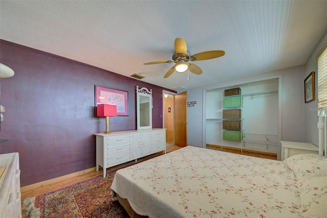 bedroom with a textured ceiling, wood-type flooring, a closet, and ceiling fan