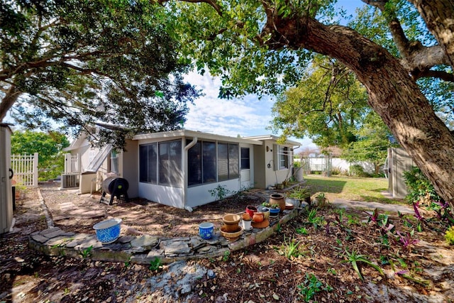 rear view of property featuring a sunroom and central air condition unit