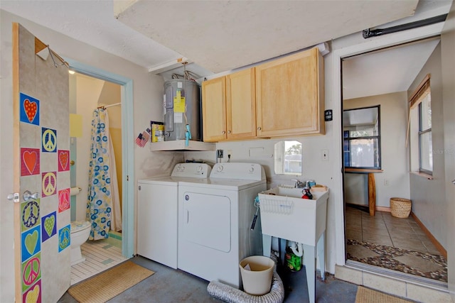 clothes washing area featuring cabinets, electric water heater, and washing machine and clothes dryer