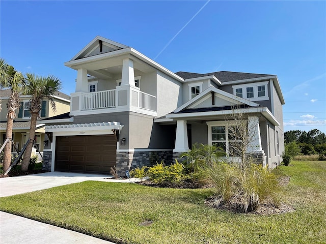 view of front facade with a garage, a front yard, and a balcony