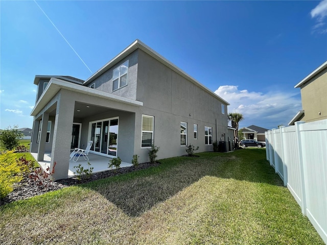 view of property exterior featuring cooling unit, a patio, and a lawn