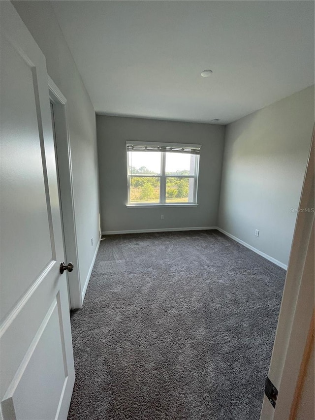 empty room featuring dark colored carpet