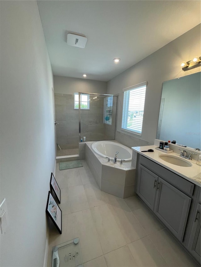 bathroom with independent shower and bath, vanity, and tile patterned floors