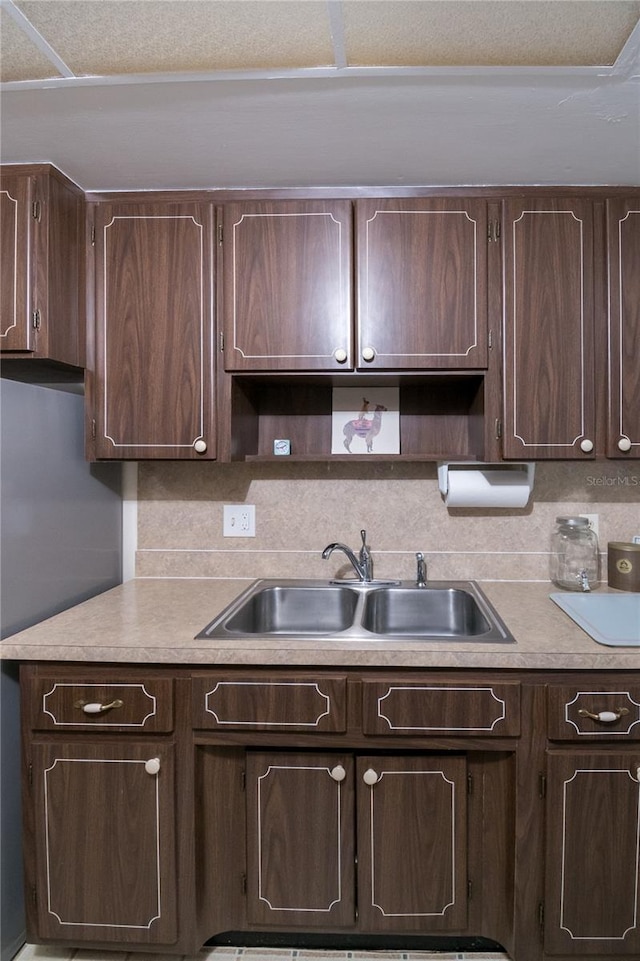 kitchen featuring tasteful backsplash, sink, and dark brown cabinets