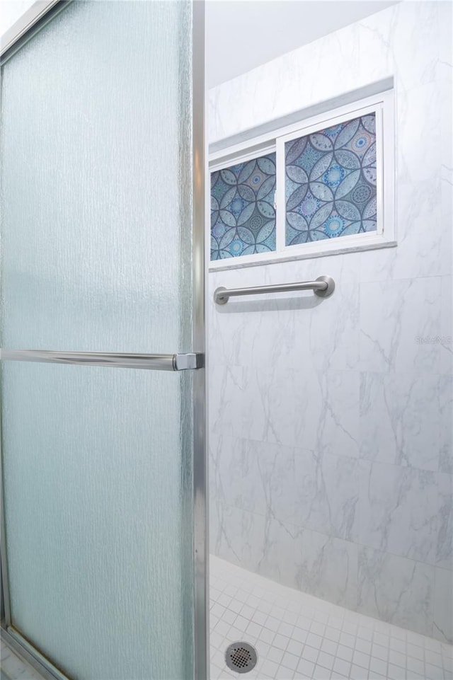 bathroom with a shower with door