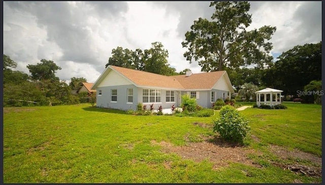 rear view of property featuring a yard