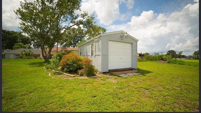 view of outdoor structure featuring a garage and a lawn