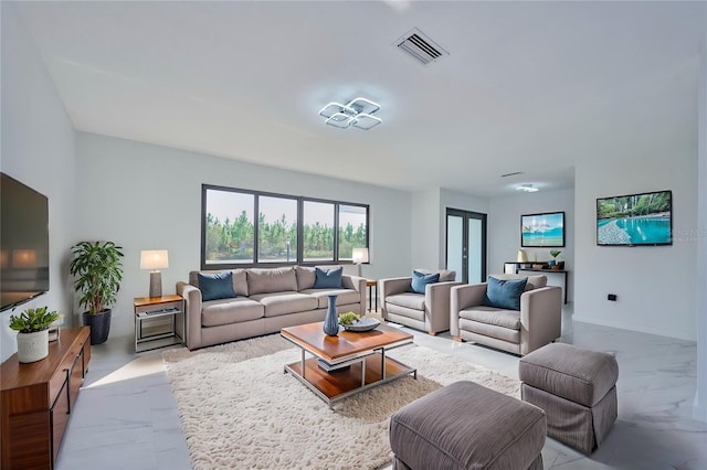 living area featuring marble finish floor, baseboards, and visible vents