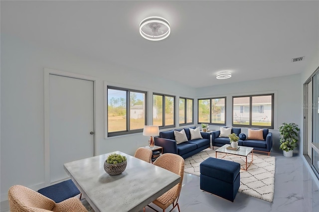 living room with marble finish floor, plenty of natural light, and visible vents