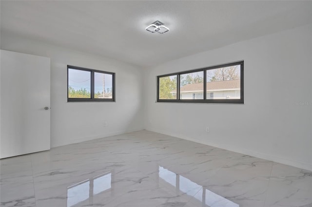 empty room with marble finish floor and baseboards