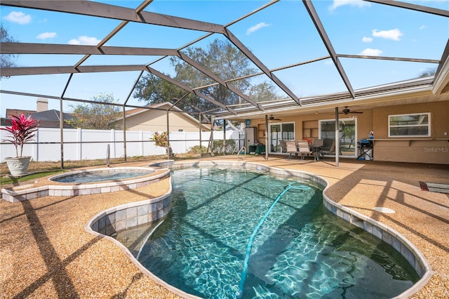 view of pool with an in ground hot tub, ceiling fan, a patio, and glass enclosure