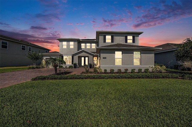 view of front facade featuring a garage and a lawn