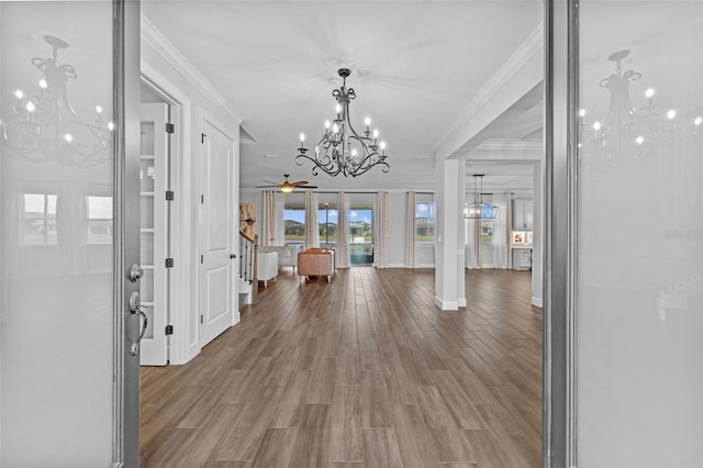 entrance foyer featuring ornamental molding, hardwood / wood-style floors, and a notable chandelier