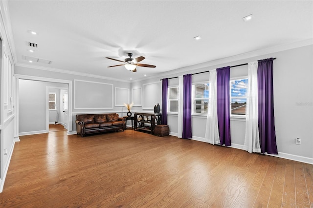 unfurnished living room with ceiling fan, ornamental molding, and light wood-type flooring