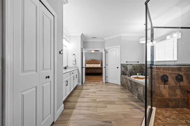 bathroom with crown molding, vanity, independent shower and bath, and hardwood / wood-style flooring