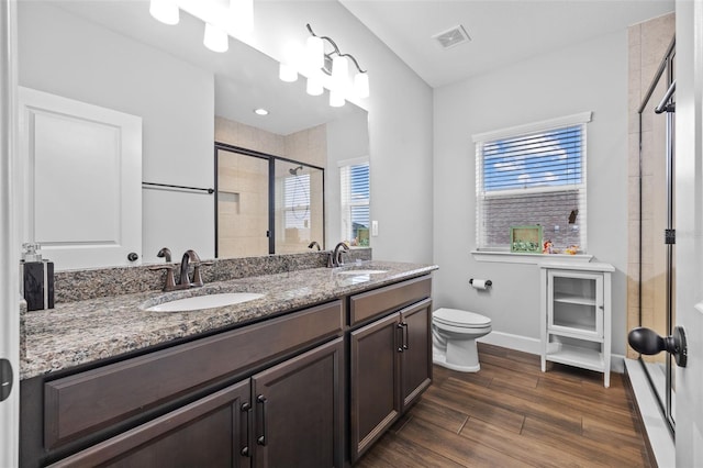 bathroom featuring wood-type flooring, toilet, an enclosed shower, and vanity