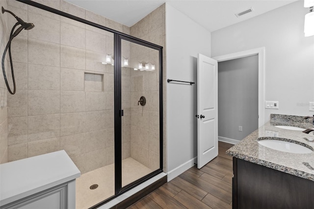 bathroom with an enclosed shower, hardwood / wood-style floors, and vanity