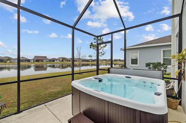 sunroom featuring a water view and a jacuzzi