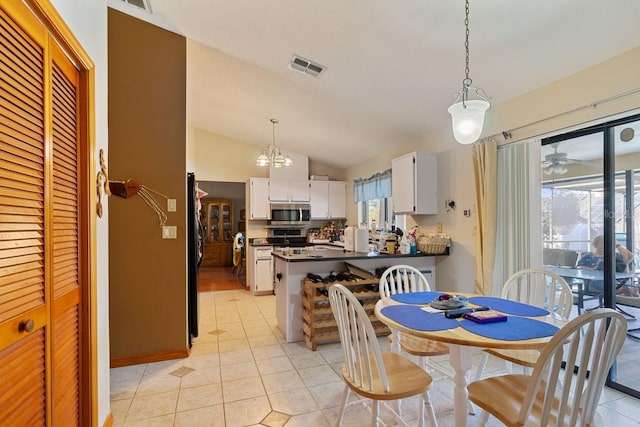 dining area with vaulted ceiling and light tile patterned flooring