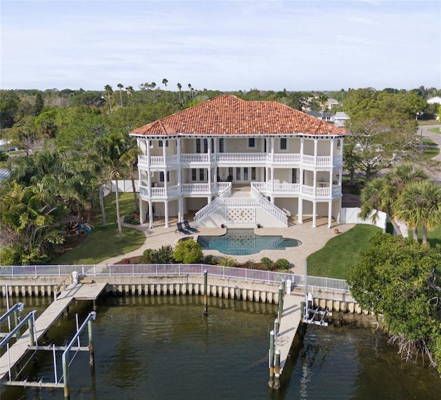 back of property with a patio, a lawn, and a swimming pool side deck with water view