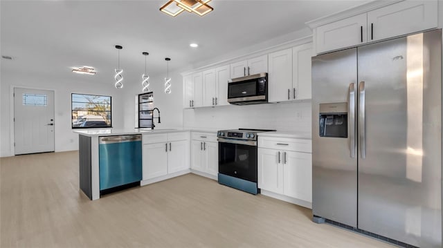 kitchen featuring stainless steel appliances, decorative light fixtures, kitchen peninsula, and white cabinets