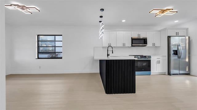 kitchen with sink, hanging light fixtures, appliances with stainless steel finishes, white cabinets, and backsplash