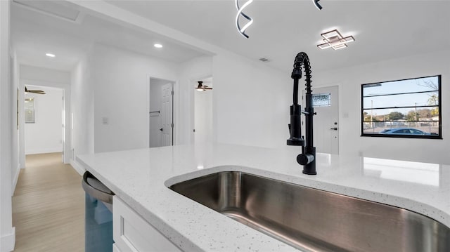 kitchen featuring light stone counters, sink, dishwasher, and ceiling fan