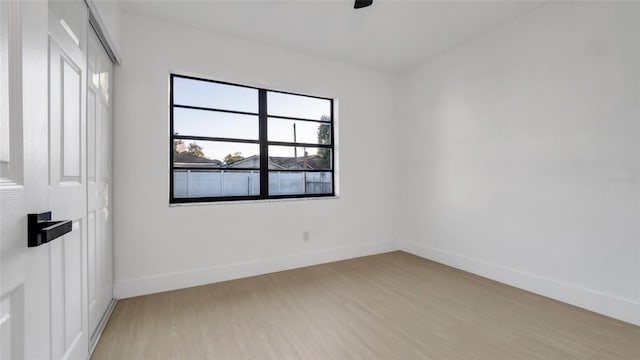 empty room with ceiling fan and light hardwood / wood-style floors