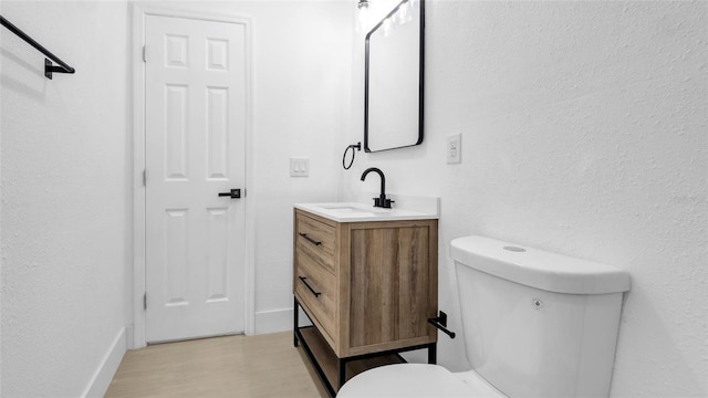 bathroom with vanity, hardwood / wood-style floors, and toilet