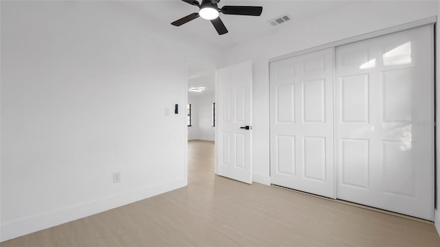 unfurnished bedroom with ceiling fan, light hardwood / wood-style floors, and a closet