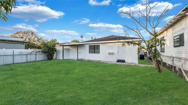 rear view of property featuring a lawn