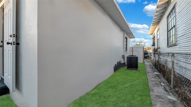 view of home's exterior featuring cooling unit and a yard