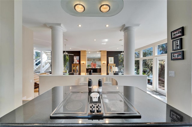 kitchen with black electric cooktop, ceiling fan, and ornate columns