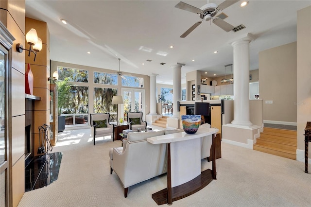 living room with light colored carpet, ceiling fan, and ornate columns