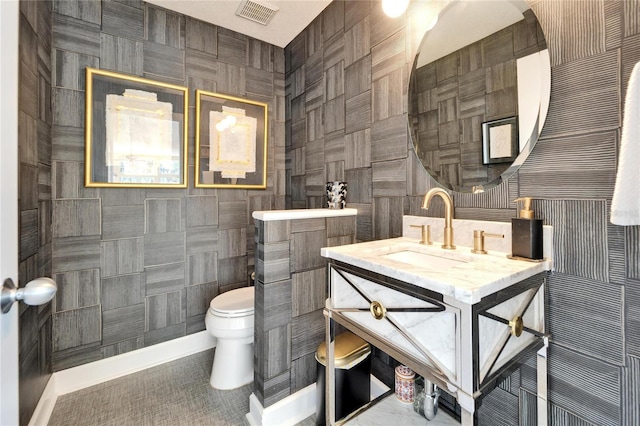 bathroom featuring toilet, sink, and tile walls