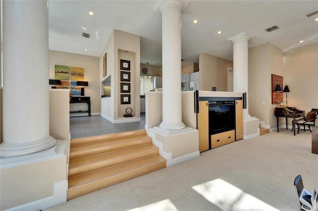 carpeted living room with ornate columns