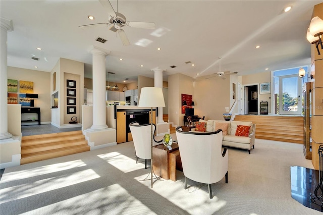 carpeted living room featuring ornate columns and ceiling fan